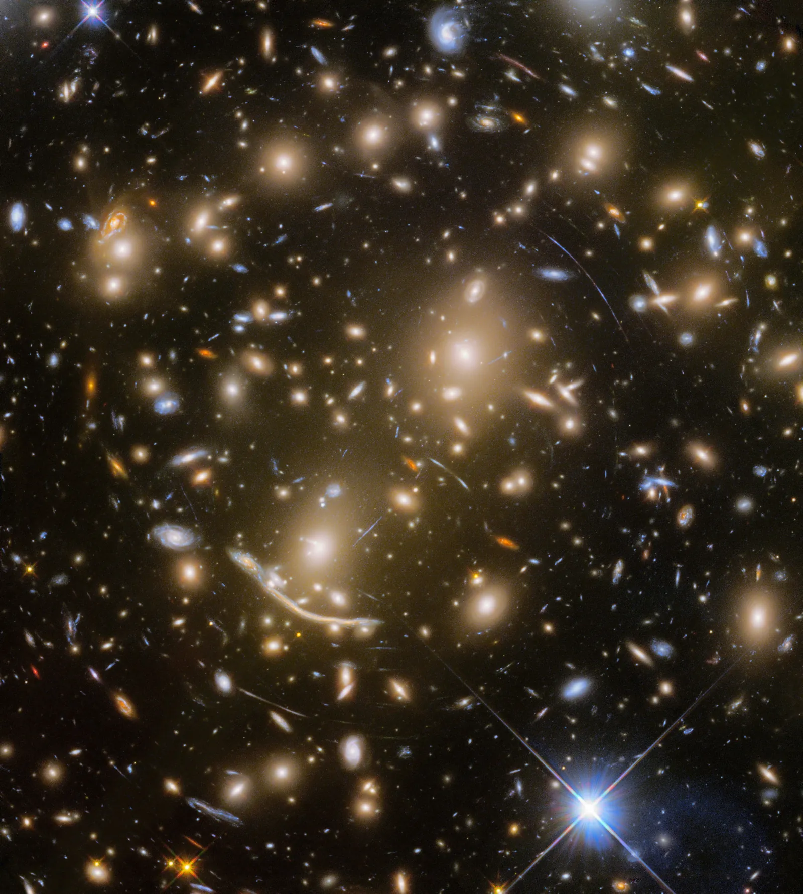 The massive galaxy cluster Abell 370, whose gravity bends the light of background galaxies into long luminous arcs.
