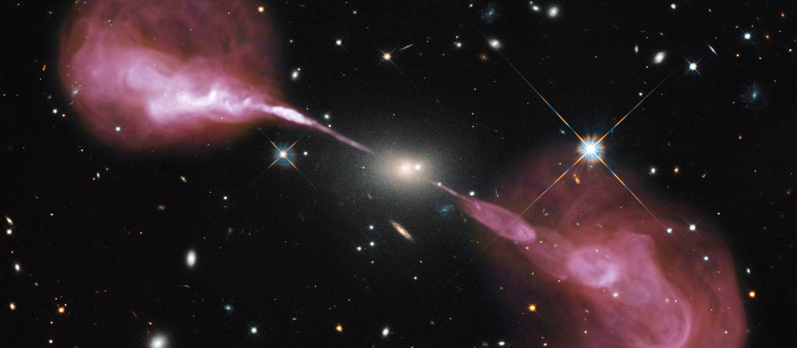 The radio galaxy Hercules A: two jets shoot out of the central elliptical galaxy and end in large lobes of radio-emitting plasma