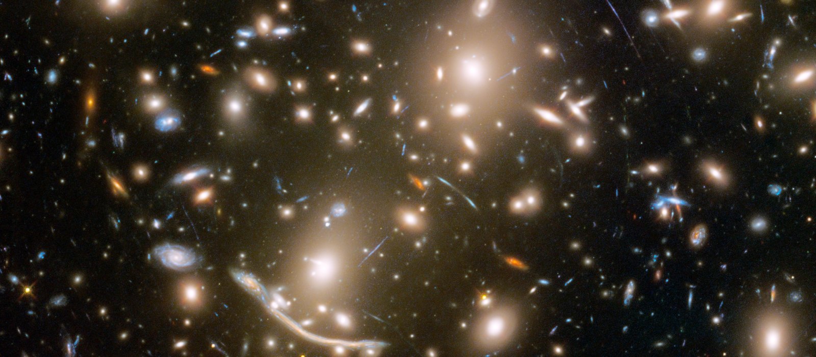 The galaxy cluster Abell 370 seen by the Hubble Space Telescope, with background galaxies stretched into arcs by gravitational lensing